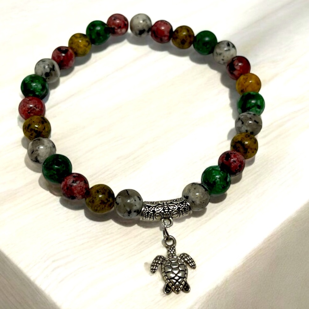 A turtle charm adorned with colorful stone beads 8.5 inch stretchy bracelet
